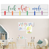 Sawysine Look What I Made sign with clips on a wooden display frame showcasing kids' artwork