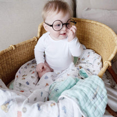 aden + anais Dream Blanket spread in a crib for cozy newborn nursery comfort.