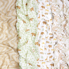 aden + anais Essentials swaddle blankets in use around a baby for snug, breathable comfort.