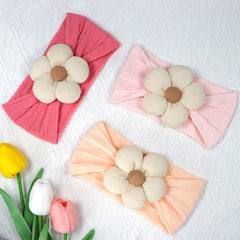 ALinmo baby wearing headband during newborn photos for comfortable styling.