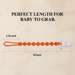 AmazingM clip attached to baby clothing for quick pacifier access.