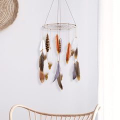 ANROYE Boho Feather Mobile hanging above crib in serene nursery for calming bedtime ambiance.