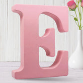 AOCEAN 8-inch pink wood letter on desk for personalized name displays.