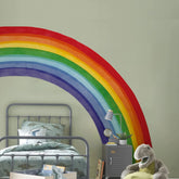 Astrkiz half rainbow wall decal assembly creates a bold, playful focal point in a kid's room.