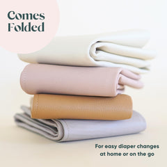 Ava + Oliver vegan leather changing mat laid flat, durable surface supports newborn to toddler diaper changes.