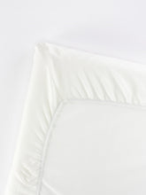 BabyBjörn Travel Crib Light fitted sheet folded, showing soft organic cotton and compact storage.
