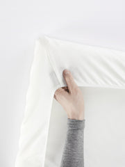 BabyBjörn Travel Crib Light sheet on mattress, showing snug fit with secure elastic.
