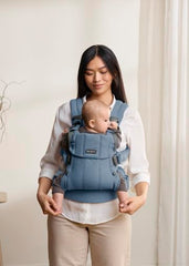 BabyBjörn Harmony blue newborn position promotes closeness and hip-friendly alignment.