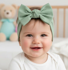 BABYGIZ Linden Green headband worn by a baby girl during play.