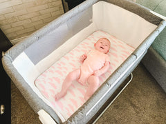 BaeBae Goods Elephants print sheet spread on a bassinet pad for cozy daytime naps.