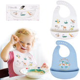 BEBE FAVOUR white giraffe bib on table catching crumbs for quick cleanup.