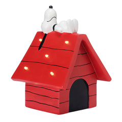 Bedtime Originals Snoopy on doghouse illuminates cozy reading moments.