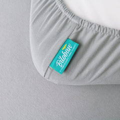 Biloban bassinet sheet gray on a bassinet demonstrates a secure full-elastic fit