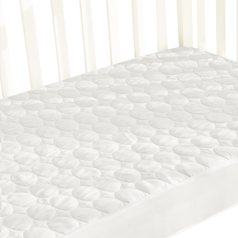 Biloban crib mattress protector on a standard mattress provides waterproof protection and a smooth sleeping surface.