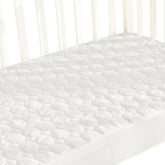 Biloban crib mattress protector on a standard mattress provides waterproof protection and a smooth sleeping surface.
