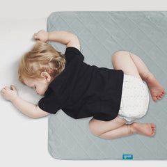Biloban waterproof crib mattress protector in gray covers spills and accidents.