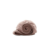Boll & Branch Signature Hemmed Crib Sheet, folded, showcases soft organic cotton and Dusty Rose for baby comfort.
