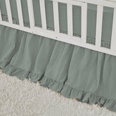 Brandream crib skirt in sage green with ruffles that hide under-crib storage.