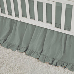 Brandream crib skirt in sage green with ruffles that hide under-crib storage.