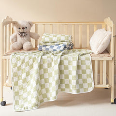 Brnabiou blanket swaddled around baby in sage green checker for secure sleep