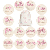 Burbell 7-pack pink milestone discs capture baby's growth milestones in photos.