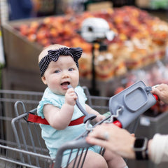 Busy Baby universal bungee straps securing bottles to a stroller for on-the-go convenience.