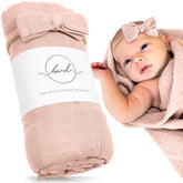 Baby Want Designs premium swaddle in dusty blush folded, highlighting ultra-soft material for newborn comfort.