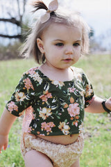 California Tot light khaki bow clip shown with neutral outfit coordination.