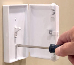 Child Be Safe hinged door closed over a switch enables quick one-handed use