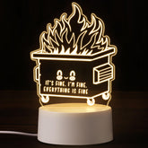 Cinnvoice dumpster fire night light glows warm on a bedside table, creating cozy ambiance.
