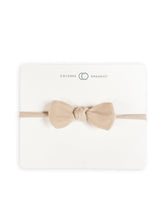 Colored Organics dainty bow headband clay-muslin setup shows soft organic cotton for delicate baby wear.