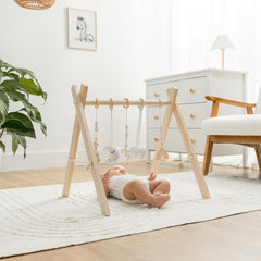 Comfy Cubs pinewood gym with hanging toys promotes visual stimulation during baby play.