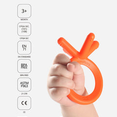 Comotomo teether orange in baby hand demonstrating grab-friendly form.