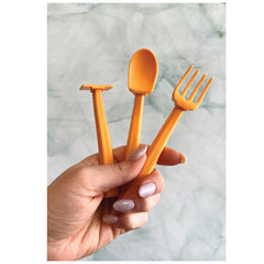 Constructive Eating orange pusher helps toddlers practice self-feeding with engaging design.