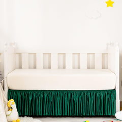 Counfeisly Blackish Green Satin Crib Skirt on bed offers silky touch for baby comfort.