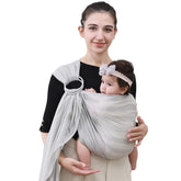 Cuby Water Baby Sling light gray stripe worn for comfortable beach carrying.