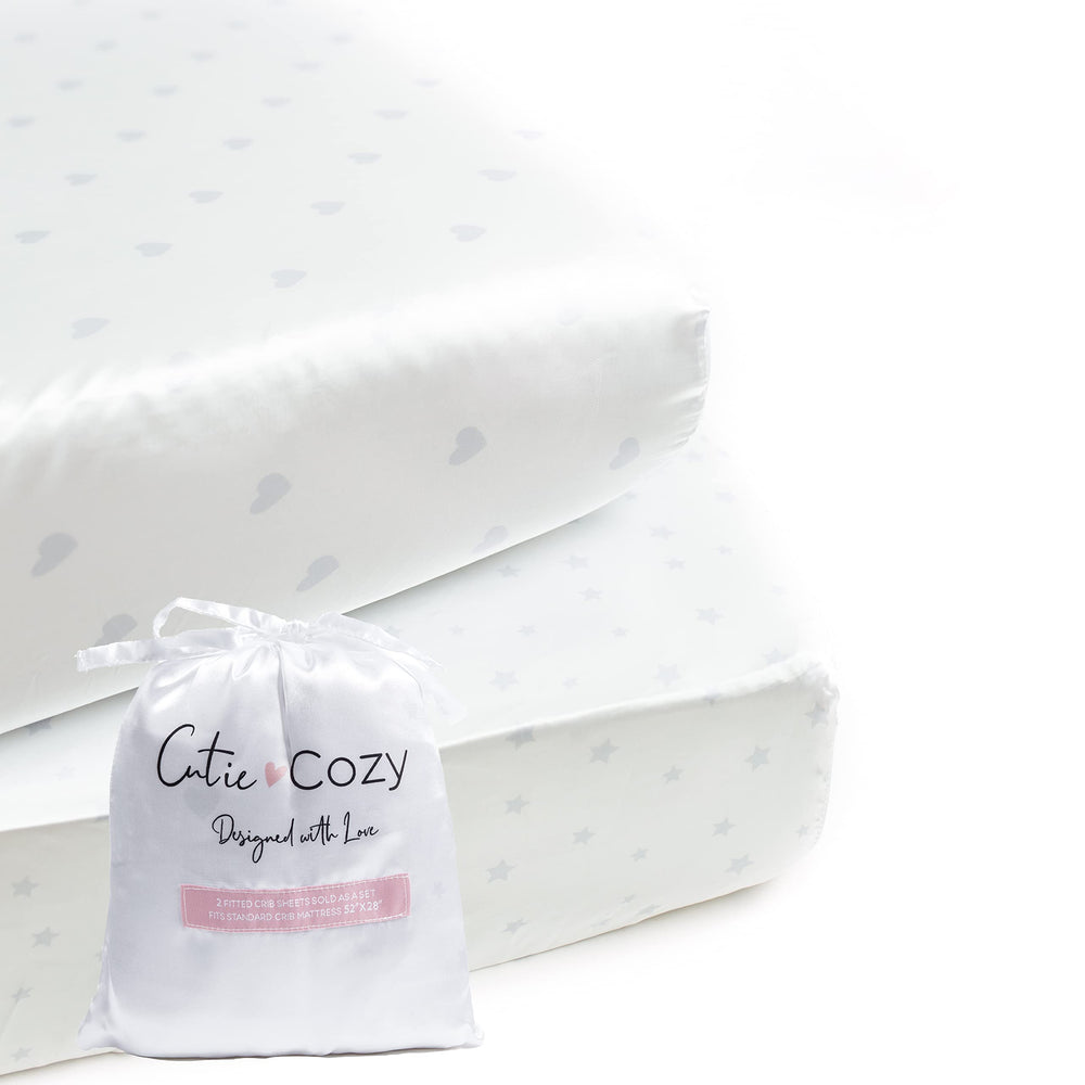 CutieCozy satin crib sheet set in white with hearts and stars, gentle on delicate baby hair.