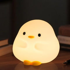 Daixinde DuDu Duck night light on bedside table offers gentle illumination for bedtime routines.