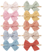 Doboi 10pcs headbands laid out with bows for newborn to toddler style inspiration.