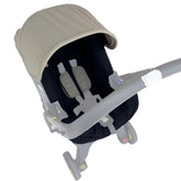 Doona sunshade cover in natural green shields sun during stroller trips.