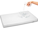 First Essentials bassinet mattress pad closeup highlights breathable rectangle comfort for newborns.