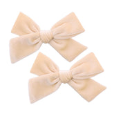 Gebelle cream velvet bow with alligator clip — secure for everyday wear.