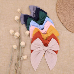 Gebelle large fable bow clip on baby's hair for party-ready style.