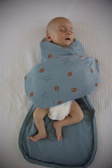 GUNAMUNA Swaddle Wrap showing arms-in-out design for versatile use.