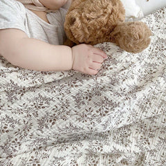 Gunnaicat nursery blanket with lace decorates a pastel crib