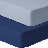 GUNTAIL baby crib sheets navy and gray folded on mattress for a secure fit.
