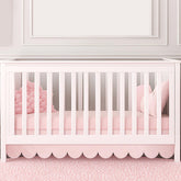 Hahafelt pink scalloped crib skirt front view adds timeless nursery charm and easy coordinating decor.