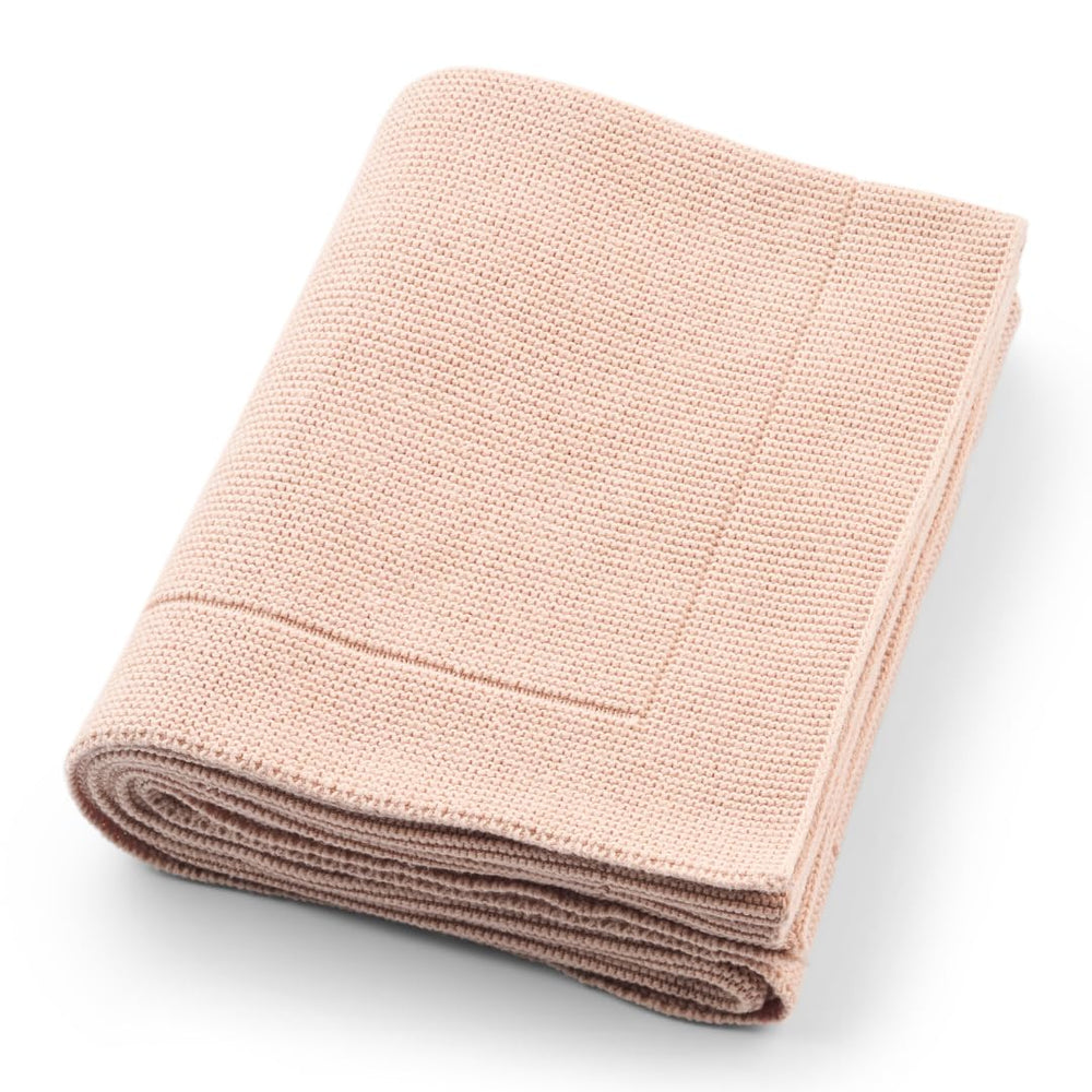 Huxie knitted baby blanket in blush folded for cozy warmth and portability.