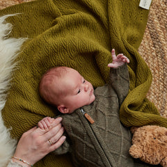 Huxie knitted baby blanket moss green on stroller demonstrating versatile all-season use