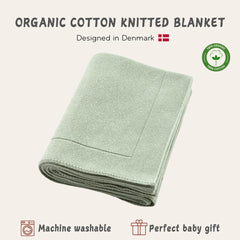 Huxie knitted organic baby blanket in crib setting demonstrates all-season warmth and breathability.